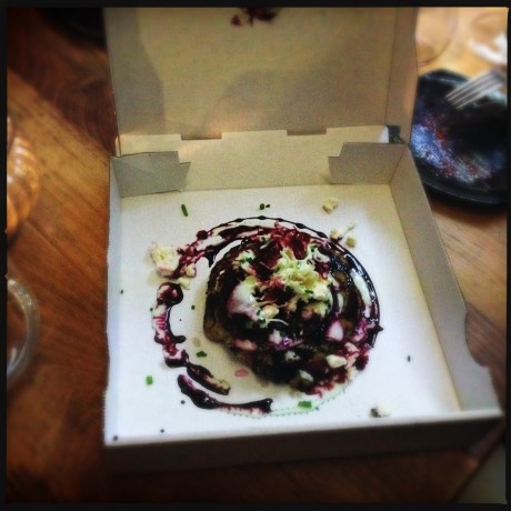 Black pudding pizza, snitsigt serverad i pytteliten pizzakartong.