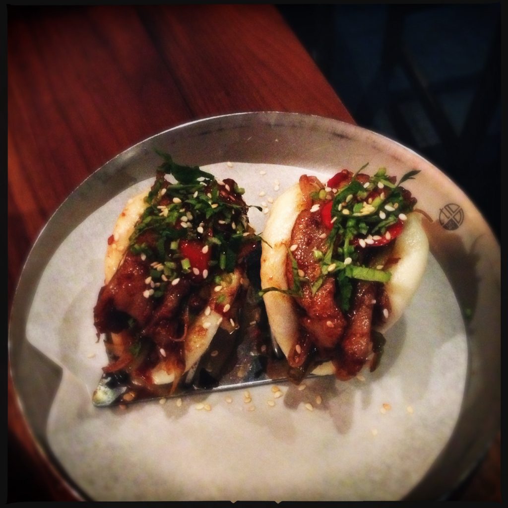 EAts hot bun crispy pork med het chilisås, koriander och sesam.