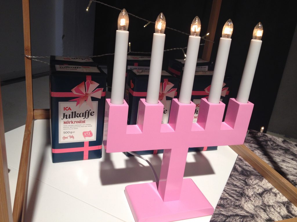 Bakom ljusstaken står Ica:s julkaffe i finfin förpackning,