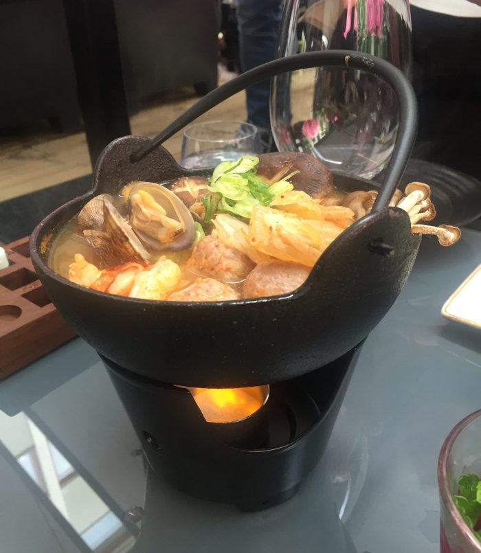 I en gryta med supergod buljong ligger kycklingfrikadeller, musslor och svamp.