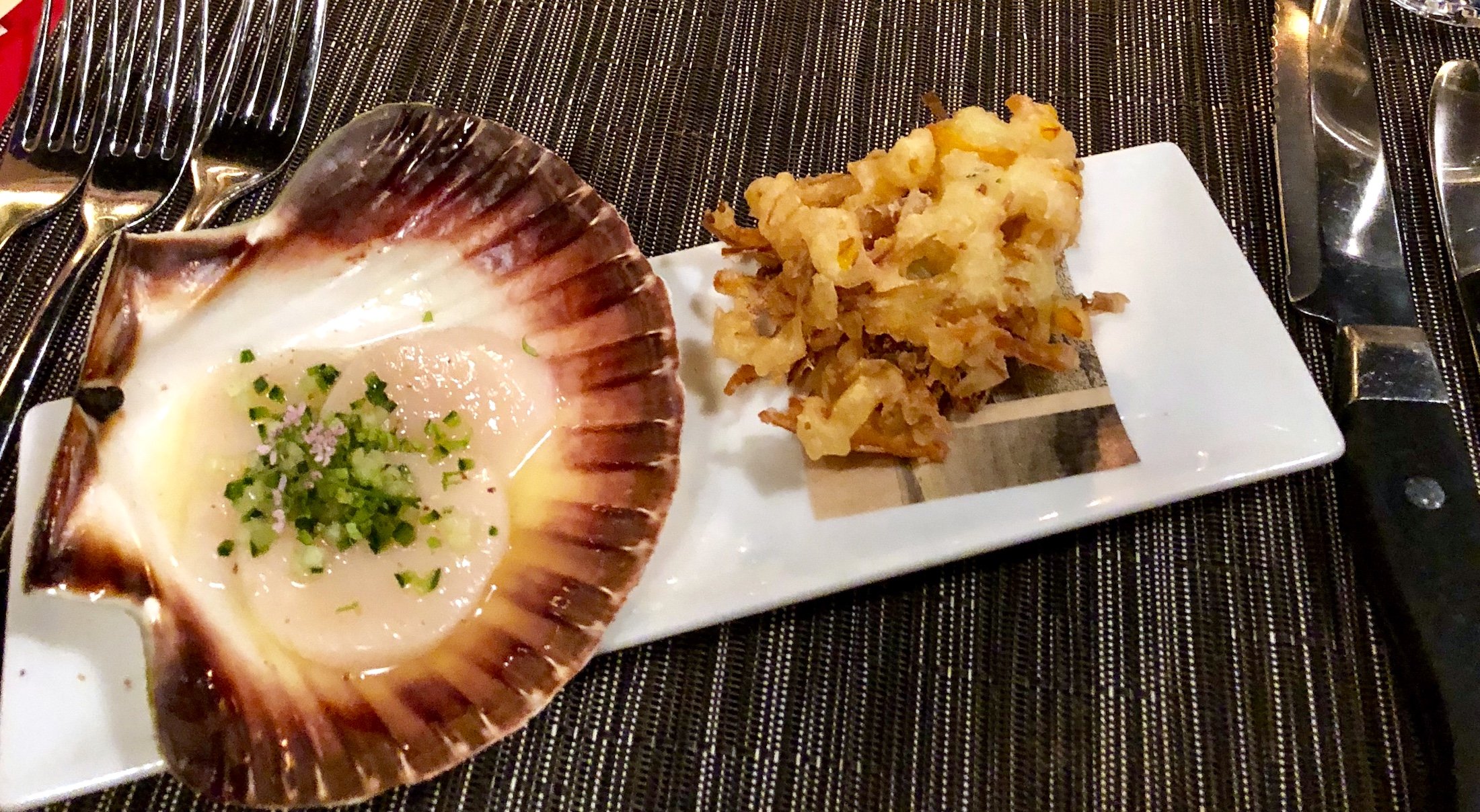 Kocken Bruce Hill serverar en pilgrimsmussla i lime och tequila med fritters på rom och grönsaker.