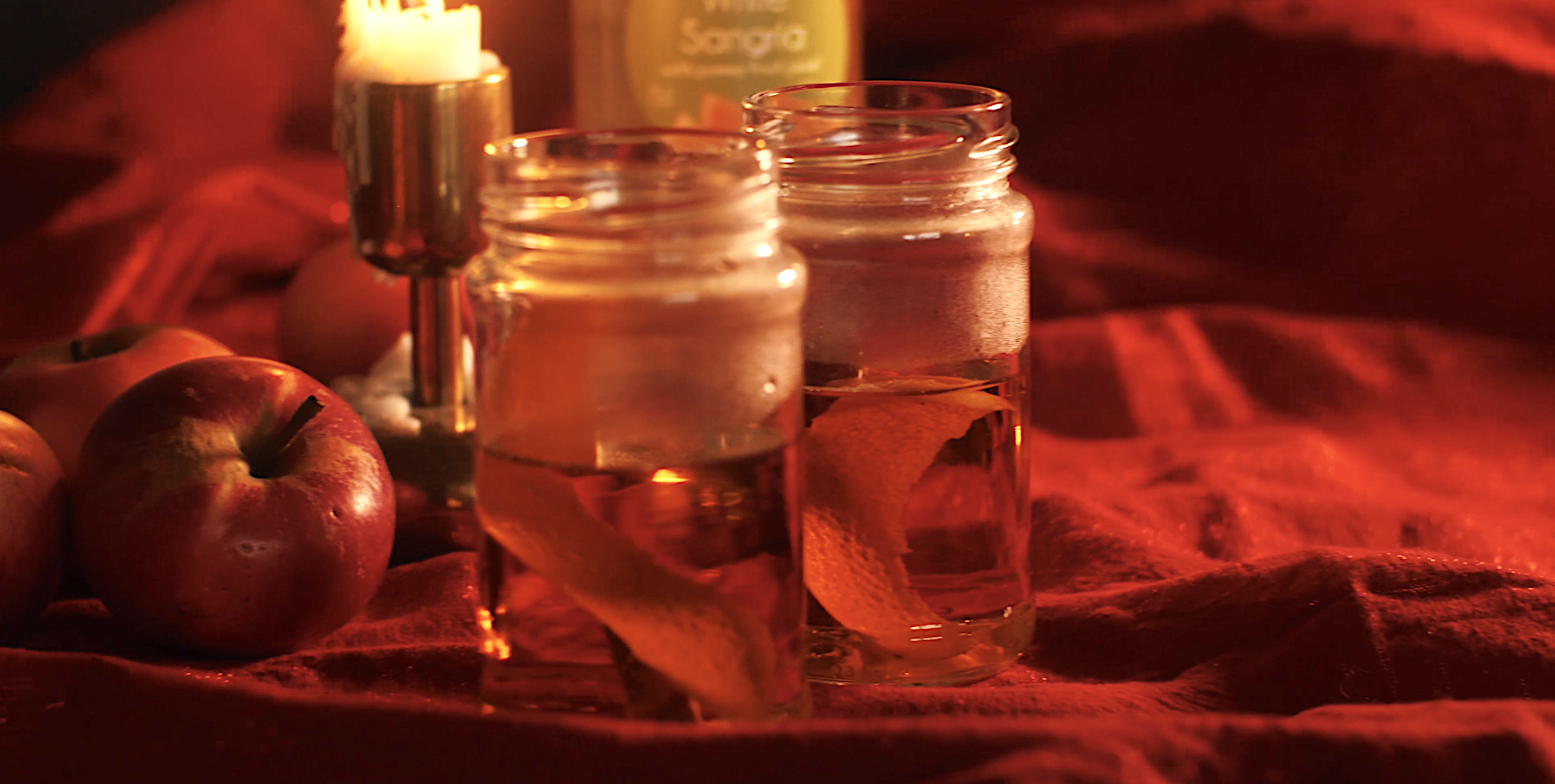 Varm vit sangria med mörk rom, kanelstång och apelsin blir en julig drink som serveras ur vanliga glasburkar.