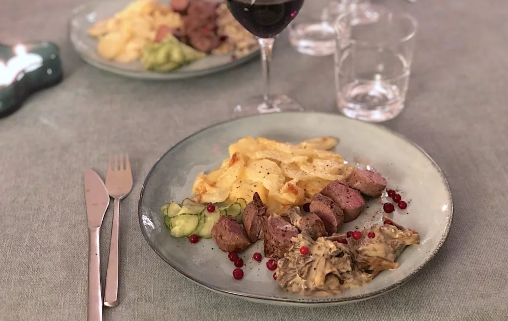 Stekt vildsvinsfilé med potatisgratäng, kantarellsås, pressgurka och lingon.