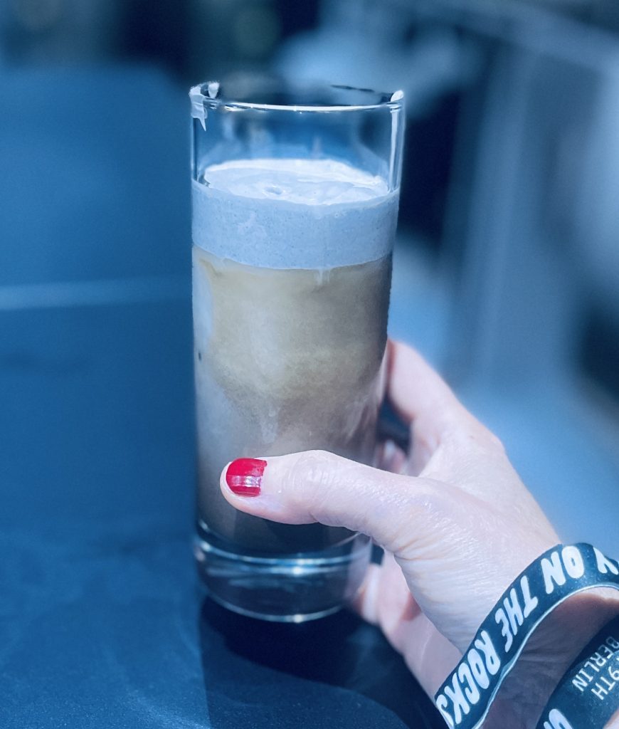 Drinken Black Sesame Hojicha Einspänner smakar både jordigt och lite svamp, med ett skum av svart sesamfrö på toppen.