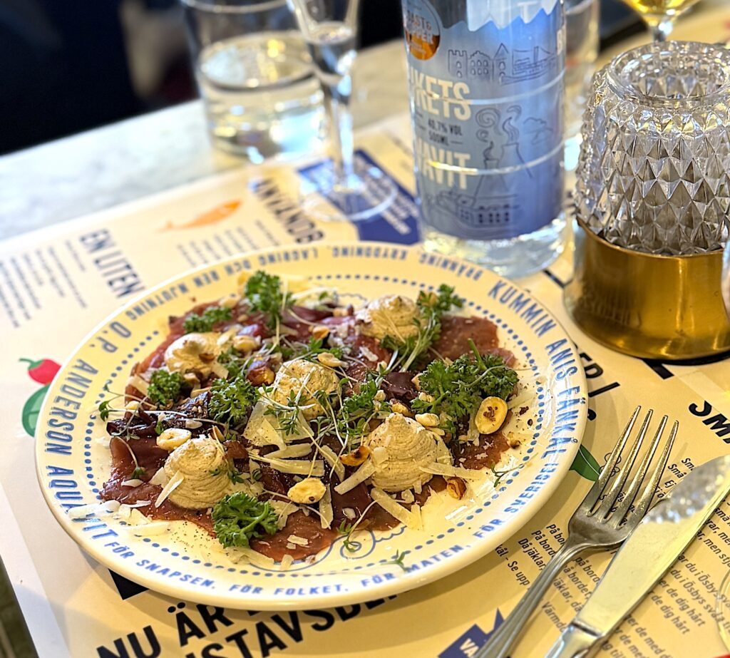 Två små svins variant av Pelle Jansson serveras med svampcrème, hasselnötter, rödvinskokt lök och lagrad ost.