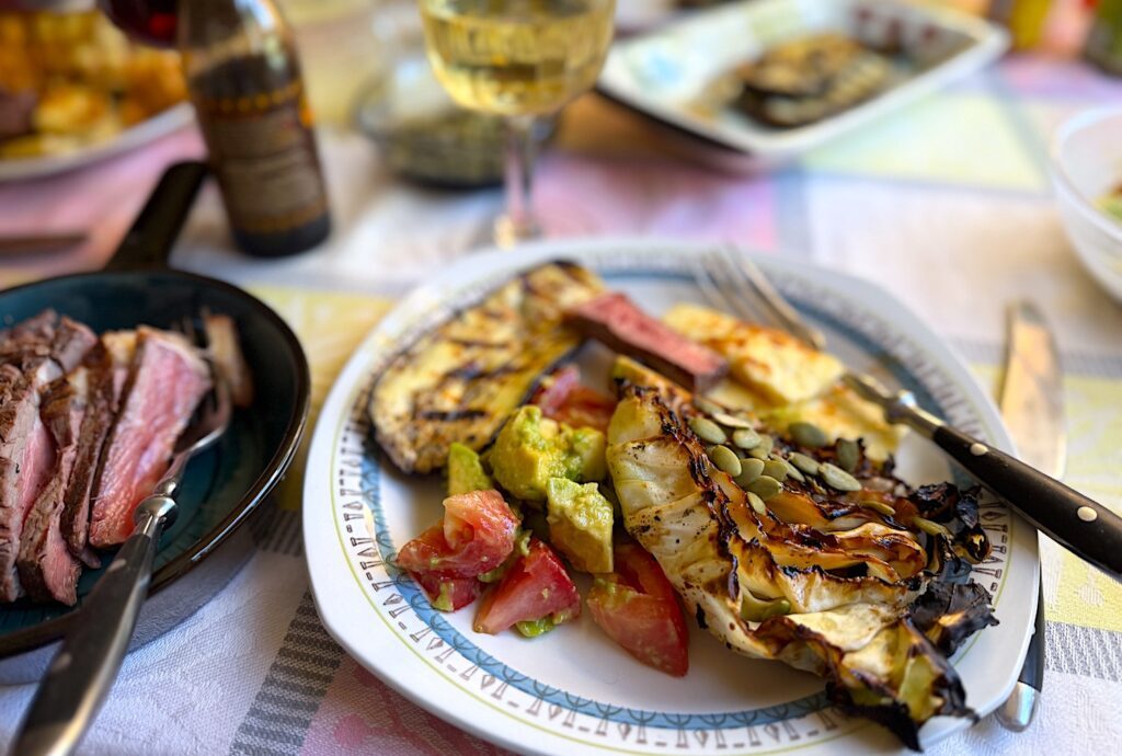 Jag serverar Grillad spetskål med BBQ-kryddsmör och pumpakärnor på en grillbuffé med halloumi, flankstek, avokadosallad och grillad aubergine.